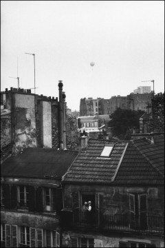 Couple âgé sur un balcon regardant une montgolfière